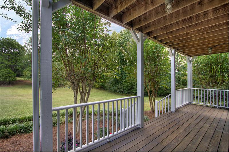 Covered porch overlooks the beautiful backyard
