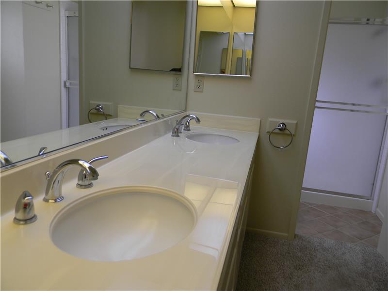 The shower and toilet are separated from the vanities
