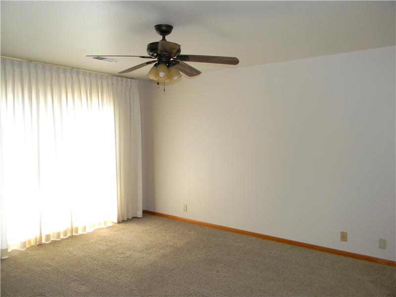 Custom drapes with shears behind cover the slider door to the patio.