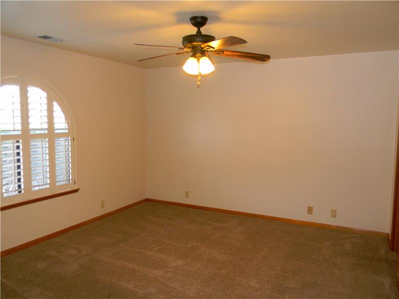 The 2nd master bedroom features plantation shutters. Both bedrooms and living room have light/fans.