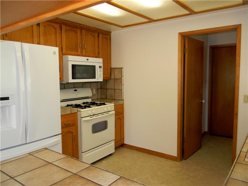 Kitchen features newer appliances, flooring and cabinet pulls.