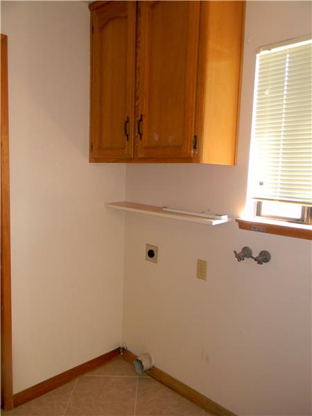 The laundry room is located between the kitchen and the garage.