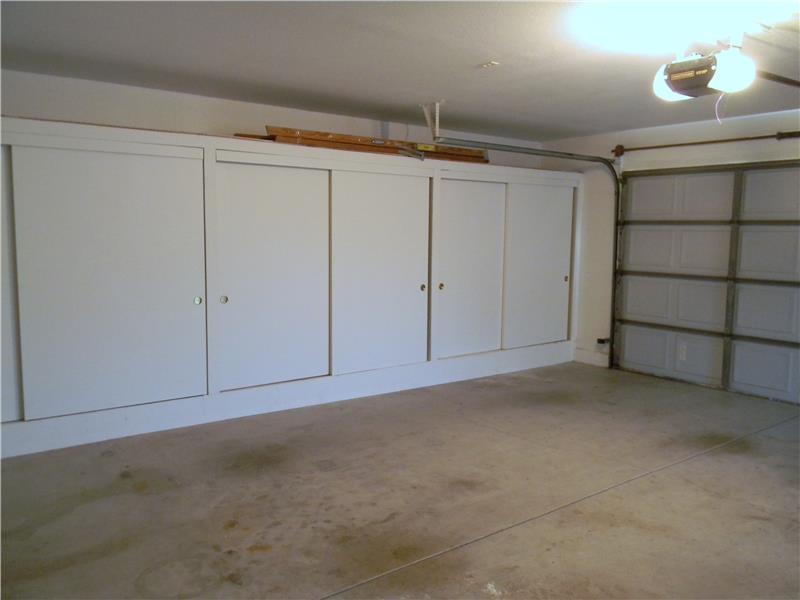 The oversized garage features a whole wall of cabinets