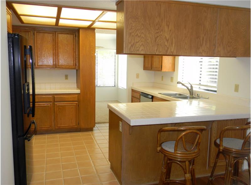 The kitchen has tile counters and floors