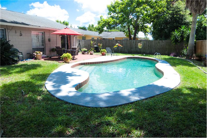 Backyard shaded by oak trees pool area