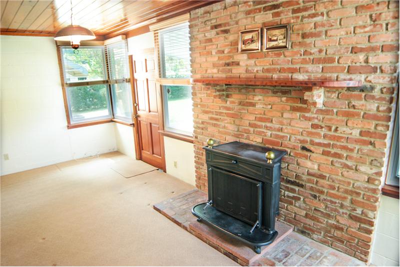 Den with Benjamin Franklin wood burning fireplace