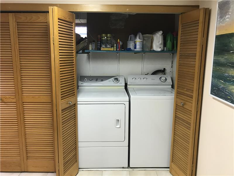 Washer Dryer in basement. Full wall of storage closets.