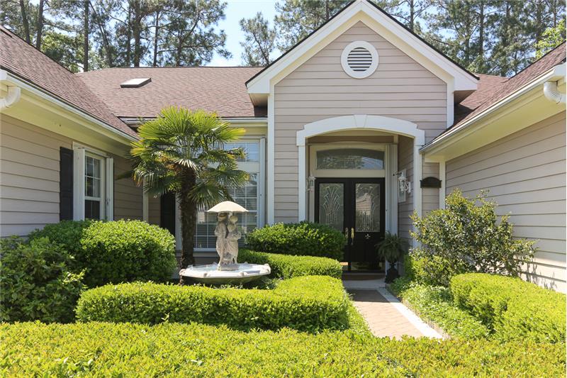 The paver driveway leads to the paver sidewalk and entry to this beautiful home.  Custom beveled glass double entry doors & scul