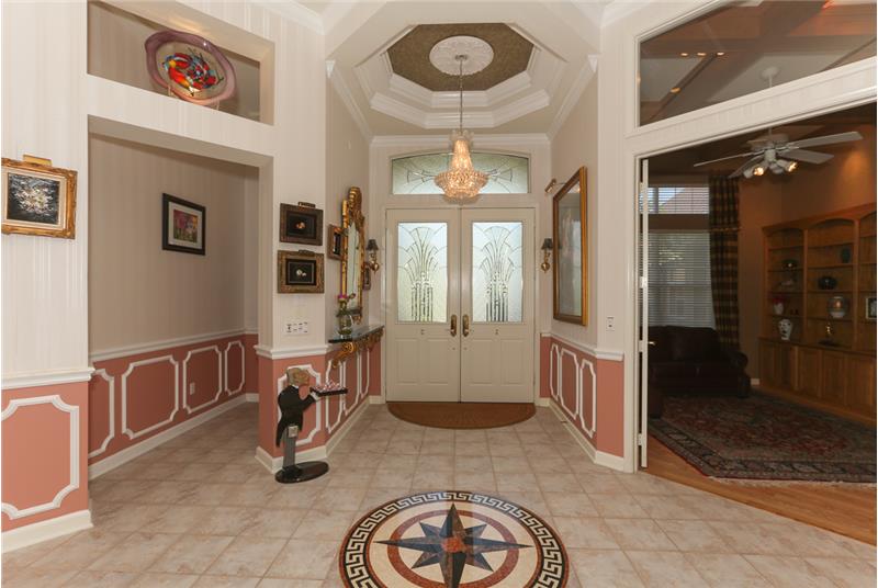 As you enter the foyer, the incredible entry inlaid tile marble compass rose, overhead crystal chandelier & stunning, double, oc