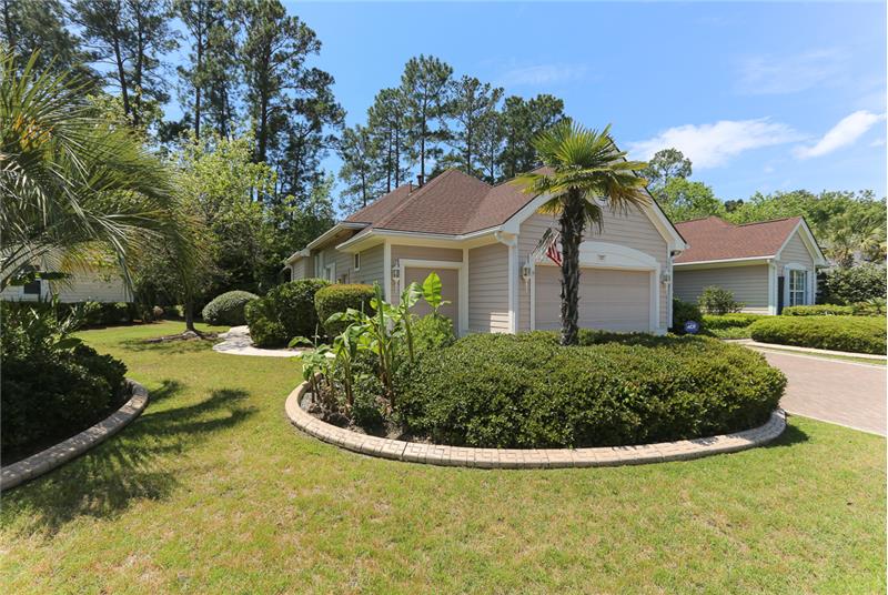 2-car plus golf cart garage is entered from the desirable paver driveway.  The side yard garden includes several palm trees and