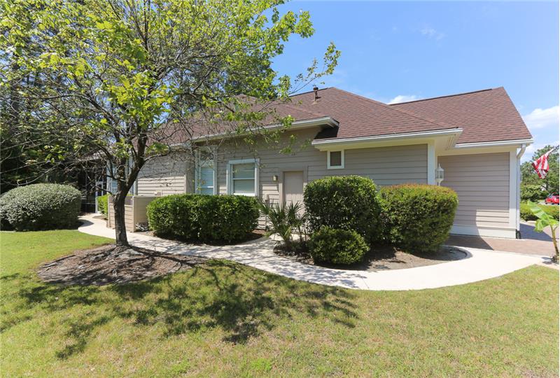 The left side of the home has a meandering sidewalk from the golf-cart garage to the lanai.