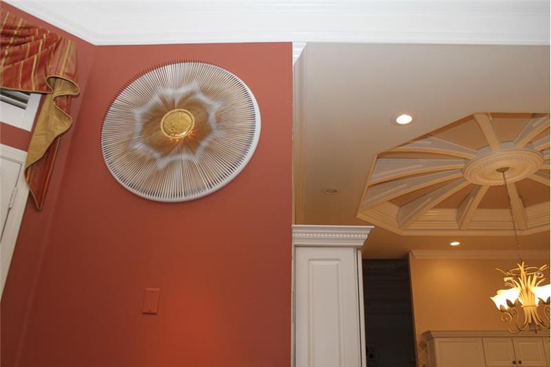 Custom metal art with hidden lighting next to the casual dining area and a view of the dome ceiling in the kitchen.