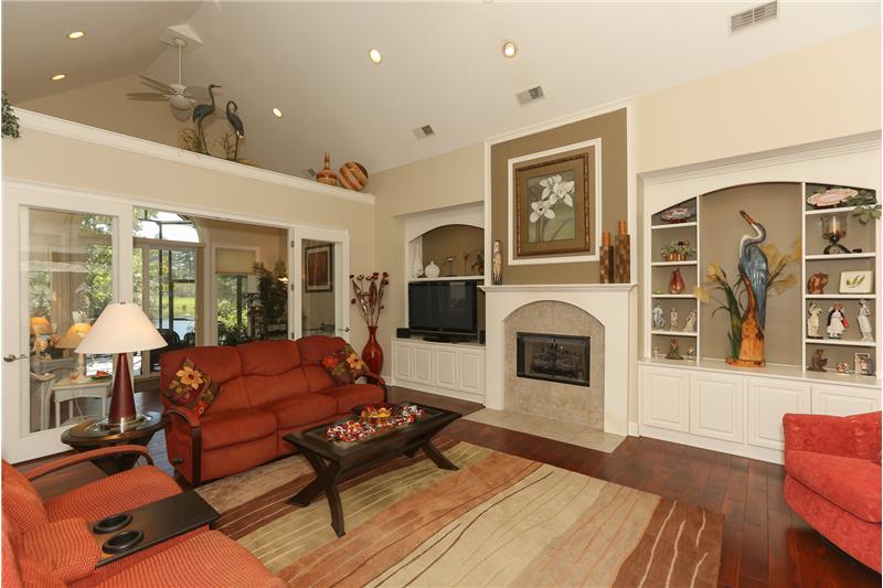 The living room has beautiful built-in cabinetry and a raised hearth gas fireplace.