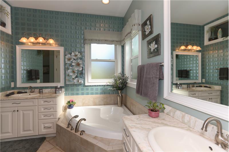 The gorgeous Owner's bathroom offers a jetted tub and a large tiled shower with 2 separate vanities.
