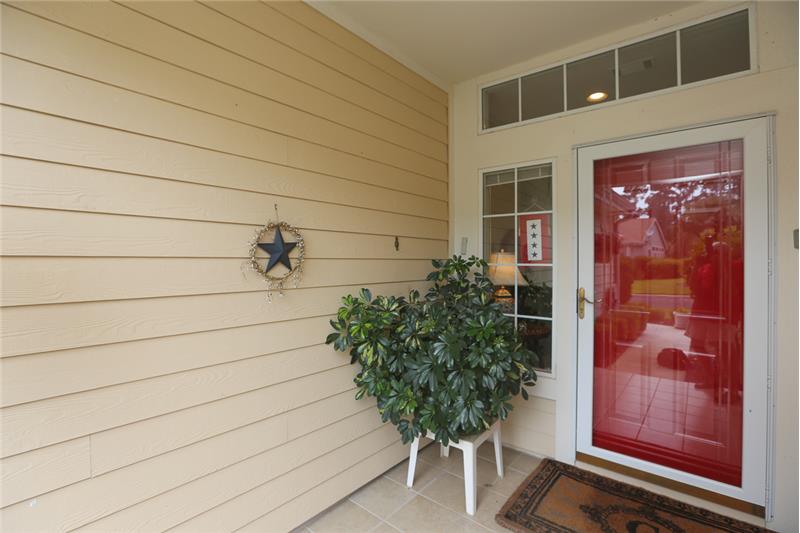 Welcome guests on the covered front porch with storm door