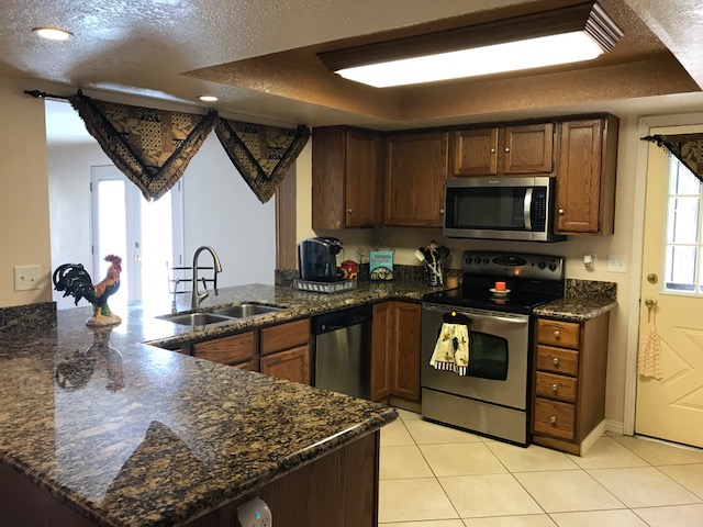 Open kitchen with granite, door to backyard and open to AZ room
