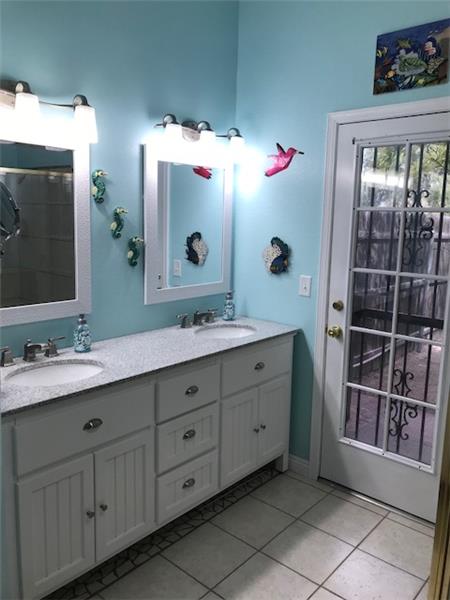 Master Bath with dual vanity and door to pool area