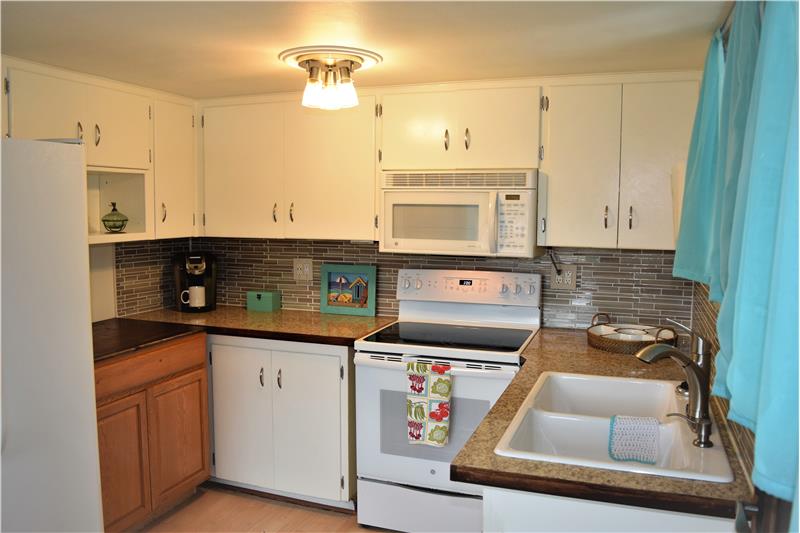 To the right, a spacious and storage-filled kitchen with new appliances and convection oven!