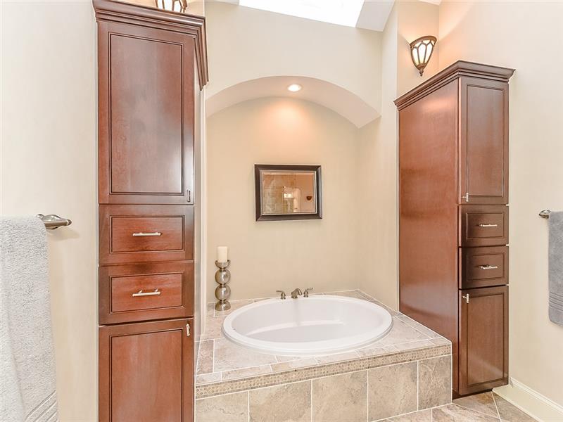 Luxurious soaking tub flanked by built-in storage.