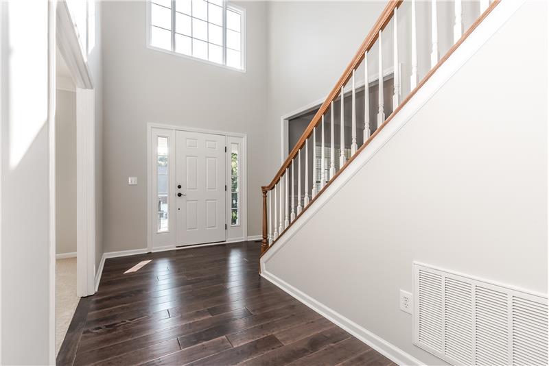 Dramatic, 2-story foyer with gleaming, new wide-plank hardwood floors.