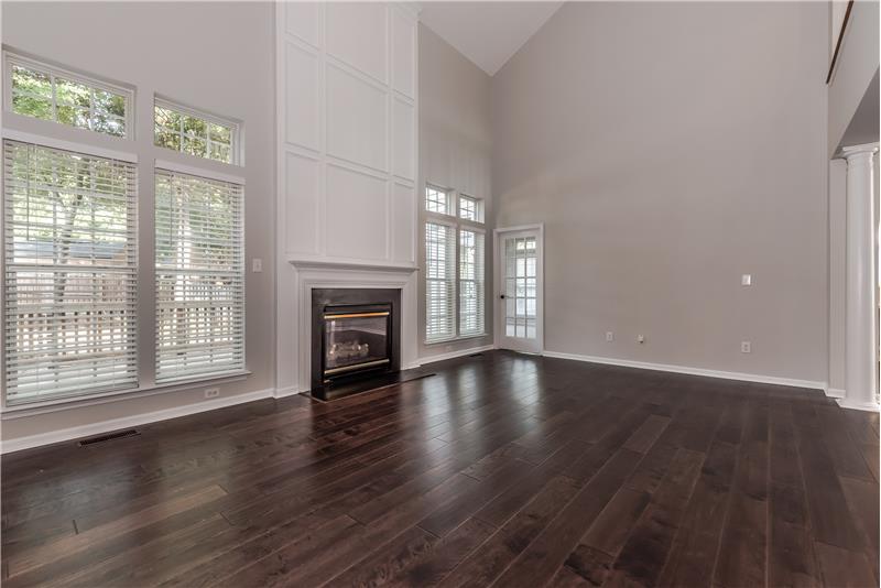 Large, 2-story great room features new wide-plank hardwood floors, fresh neutral paint, new blinds.