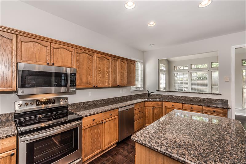 Brand new stainless steel appliances: microwave, smooth-top cook top, dishwasher, side-by-side fridge with ice/water dispenser.