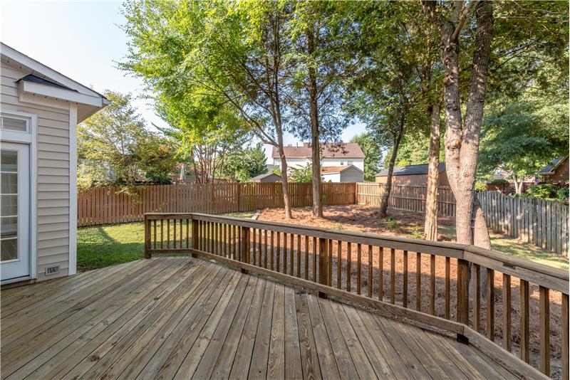 Deck enjoys privacy and overlooks back yard with shade trees.