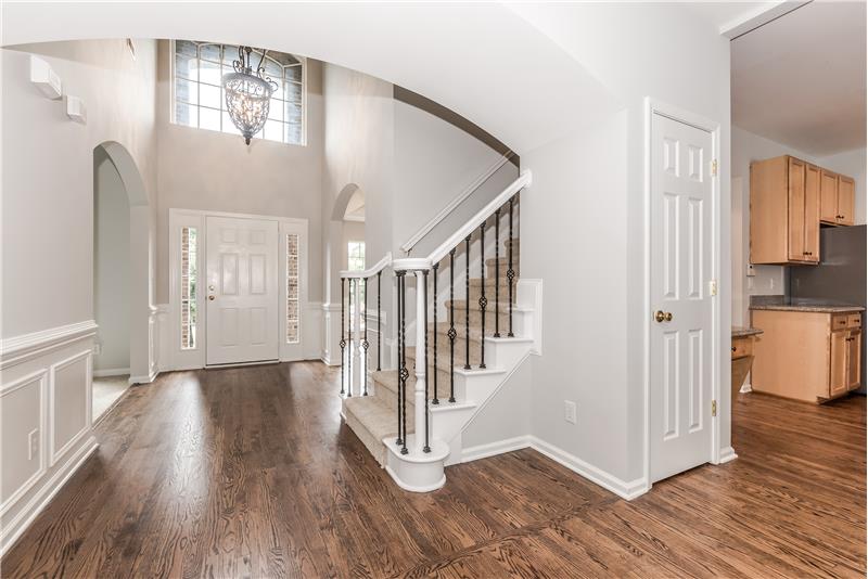 Dramatic foyer with soaring ceilings and gleaming hardwood floors.