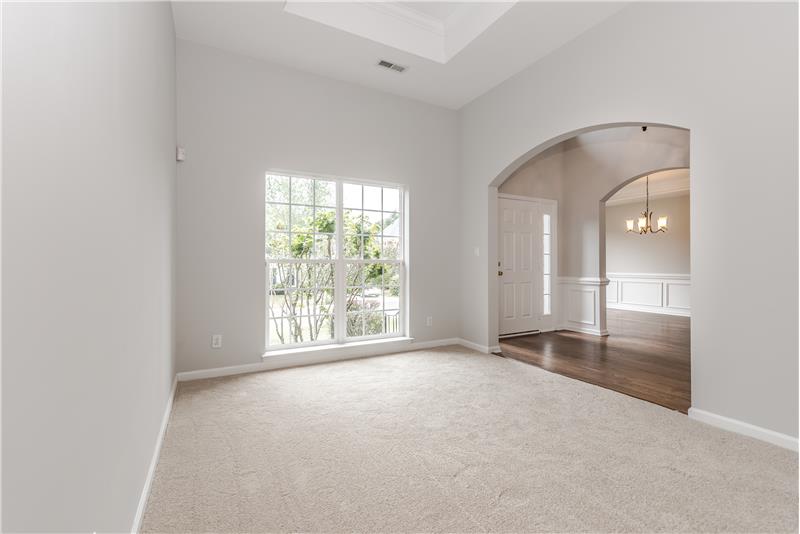 Living room features new carpet, fresh neutral paint, French-style windows.