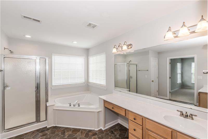 Master bathroom has a corner soaking tub, separate shower, and private WC.