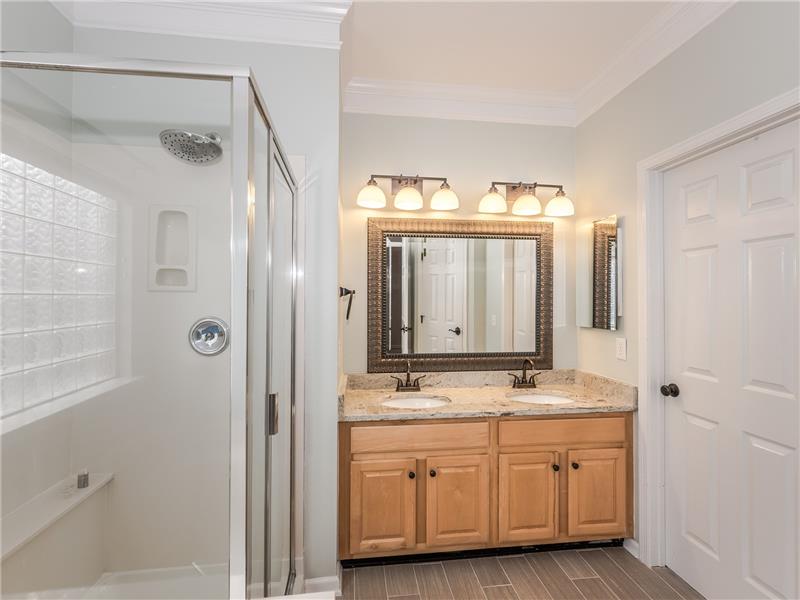 Master bathroom with double sink vanity and walk-in closet.
