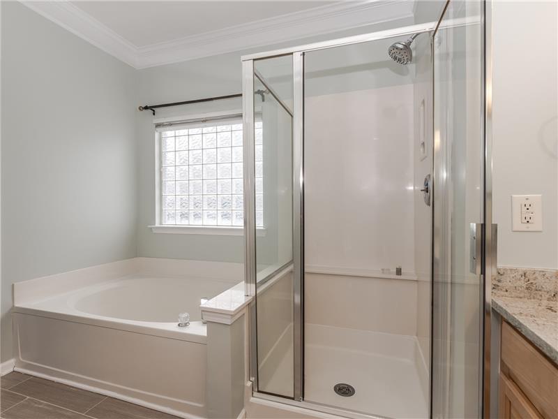 Master bathroom features soaking tub, separate shower, private WC, glass block picture window.