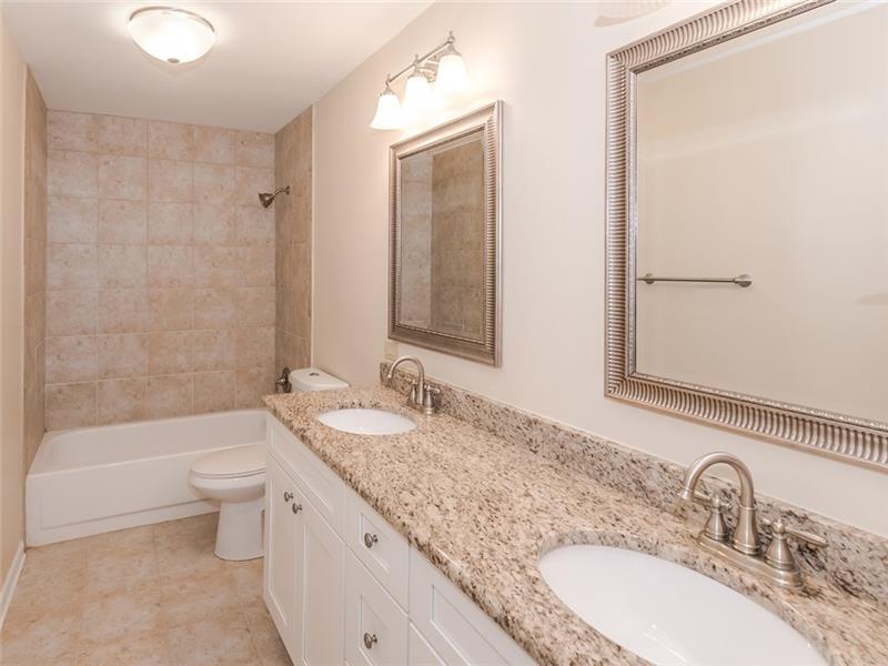 Remodeled master bath with granite counters, tile floors and surround, built-in linen storage, new toilet and light fixtures.