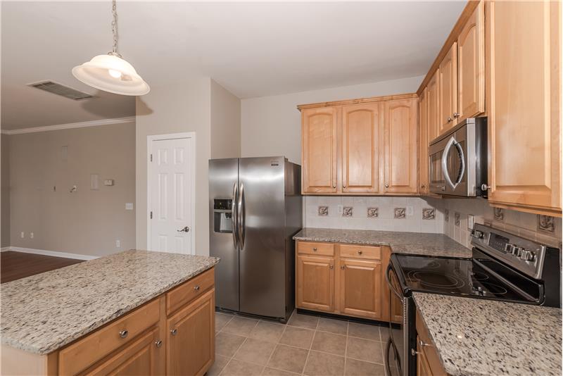 Kitchen features pantry, 42 inch cabinets, tile back splash, tile floors