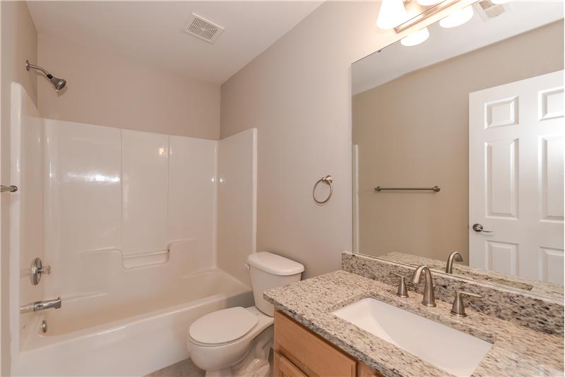 Hall bath shared by secondary bedrooms has new granite counters, new fixtures, new lights, new tile floor