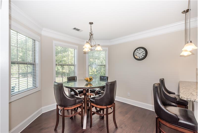 Sunny, spacious breakfast area adjacent to the kitchen. Gleaming hardwood floors, crown molding.