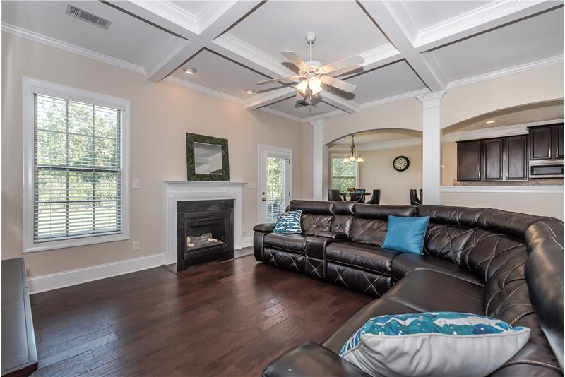 Great room with coffered ceiling also features gleaming hardwood floors, crown molding, open sight lines.