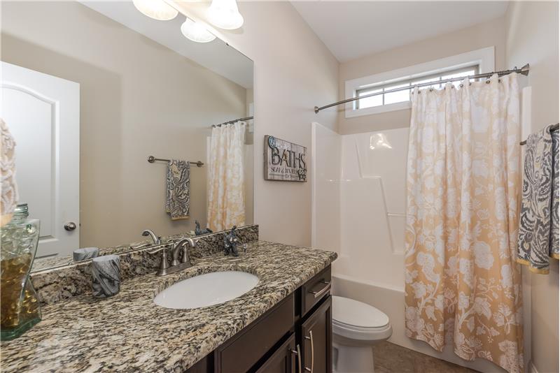 First floor bathroom features granite counter tops, tile floors, raised vanity.