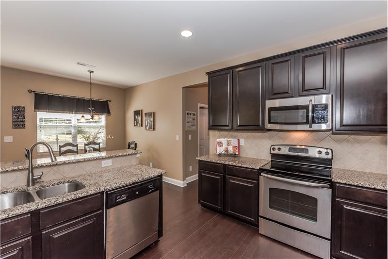 Kitchen features stainless steel appliances, tile back-splash, recessed lighting, large, walk-in pantry.