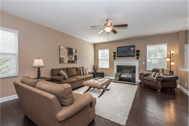 Spacious open family room with gas log fireplace with decorative mantel.