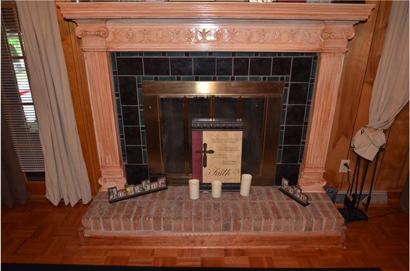 Custom hand-crafted mantel on the den's wood burning fireplace.