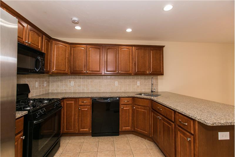 Kitchen with Cherry Cabinets, Granite Counters, Stone tile floor