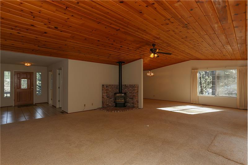 Expansive Living Room with Vaulted Wood Ceilings, Propane Burning Wood Stove, Sliding doors to private deck.