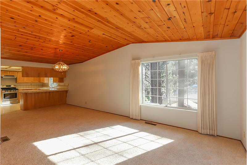 Dining Room with wood vaulted ceilings open to the kitchen with island seating.