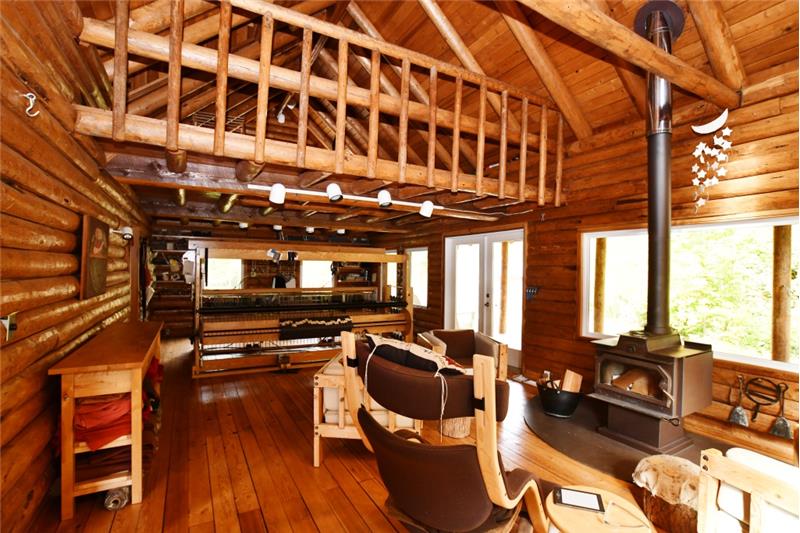 Living area with loft above, Country brand stove, vaulted ceilings and big enough for a full size rug loom