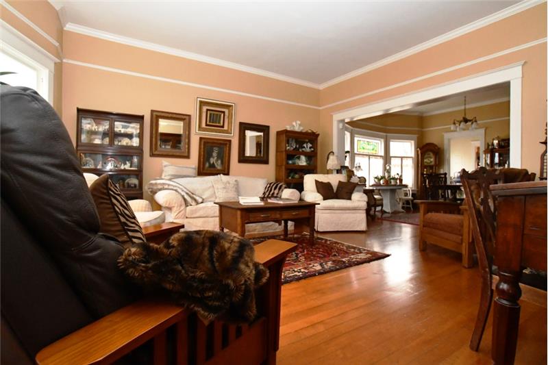 Living room with gleaming original fir floors, picture-railing, crown molding and room for lots of furniture.