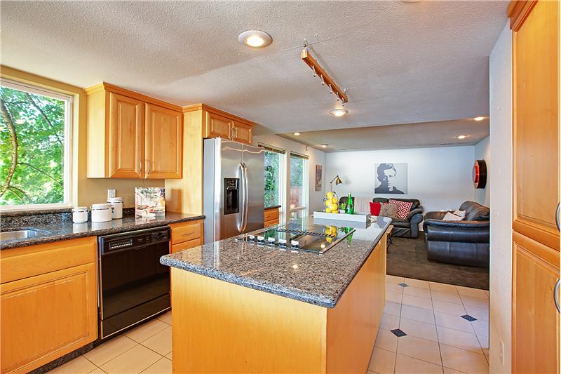 Kitchen Features Custom Cabinets, Center Island, Eating Bar, Granite Slab Counter Tops and Tile Floors.