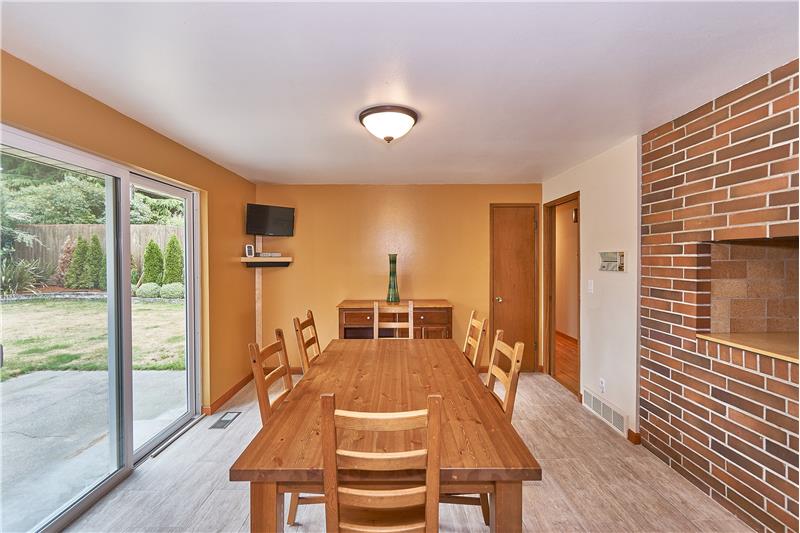 Huge Breakfast Nook with Newer Tile Ceramic Floors, Brick Surround Grill and Vinyl Slider leading to the Private Backyard