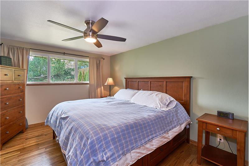 Large Master Bedroom with Ceiling Fan, Freshly Painted, Gleaming Hardwood Floors and Newer Vinyl Window.