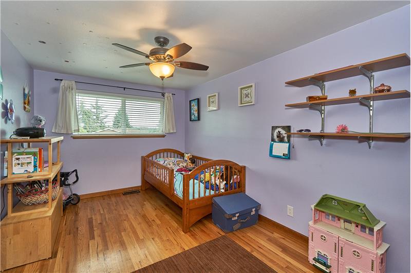 Generous Sized Upstairs Bedrooms with Gleaming Hardwood Floors, Ceiling Fans and Vinyl Window.